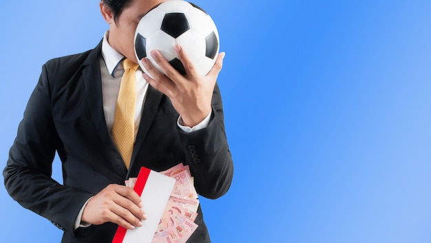 Businessman holding a soccer ball and envelope with money. Concept of 'Football Agent' involved in transfer deals.